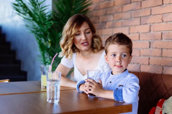 Young mom is looking angry with her boy, he looks like he does not listening.