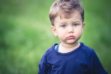 Güzel mavi gözlü mavi t-shirt sevimli küçük sarışın çocuk.