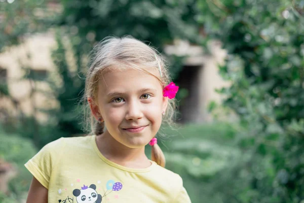 Retrato de adorable niña rubia con ojos verdes amarillos en el jardín —  Fotos de Stock