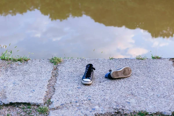 Empty shoes on the river bank. Suicide, International day of dis — Stock Photo, Image