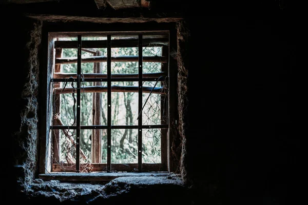 Staré sklepní okno s kovovými mřížemi. Slabý světlo. Izolace, koncepce únosu — Stock fotografie
