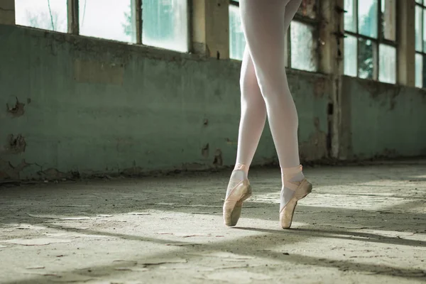 Photo of ballerinas toe walking in an old building, rustic surrounding. — Stock Photo, Image