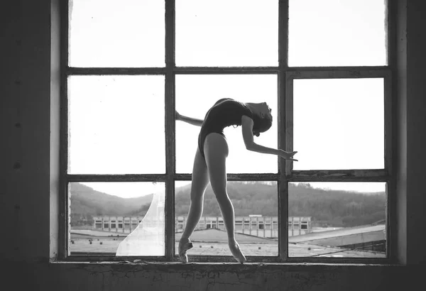 Photo en noir et blanc de la ballerine dans le cadre de la fenêtre d'un vieux bâtiment . — Photo