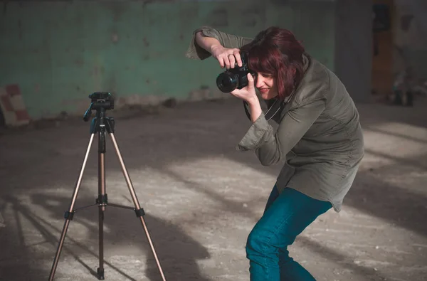 Fotógrafo feminino com câmera dslr tirando fotos no local da sessão de fotos — Fotografia de Stock