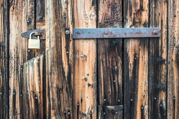 Brauner Holzhintergrund mit Vorhängeschloss. senkrechte Planken, Stangen — Stockfoto