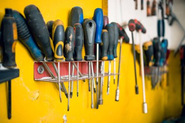 Araba tamircidükkanında sarı duvarda tornavidalar. Araba tamir ekipmanları