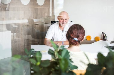 Ofiste orta yaşlı iş adamı yeni müşteri ile konuşma yapıyor.