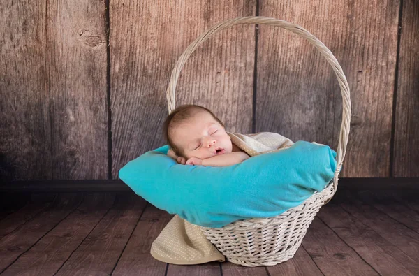 Newborn baby boy lying and sleeping in the baske. Mother's day concept. — Stock Photo, Image