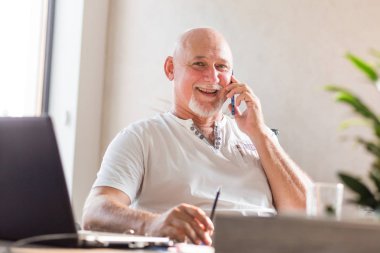 Ofiste telefonda konuşan orta yaşlı iş adamı.