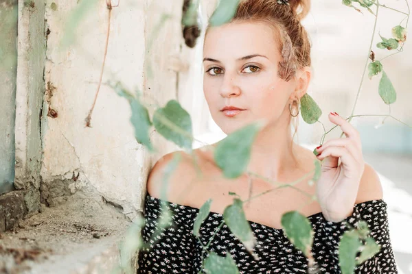 Beautiful lady with perfect skin in old building looking through the plant. — Stock Photo, Image