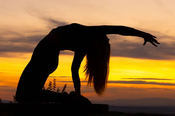Silhouette női edző jóga edzés naplementekor. Jóga koncepció. Teve szósz. — Stock Fotó