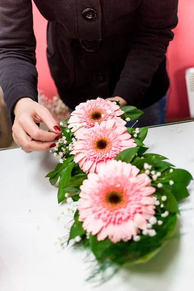 Çiçekçi kadın tarafından çiçekçide Gerbera papatya buketi hazırlanıyor.