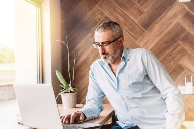 Kafede bilgisayarla çalışan orta yaşlı yakışıklı bir adam. İş, modern konsept