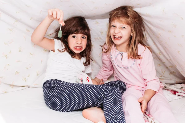 Фотографія маленьких дівчат, які їдять цукерки. стоматологічні проблеми, захист зубів . — стокове фото