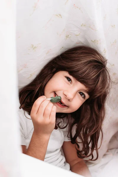 Słodka Brunetka Jedząca Cukierki Łóżku Międzynarodowy Dzień Dziecka — Zdjęcie stockowe