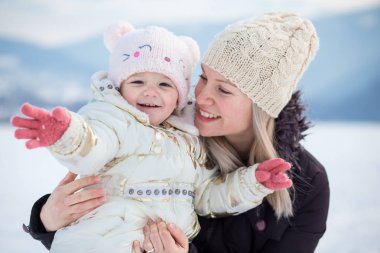 Mutlu aile, kızı olan anne, kış zamanı, açık hava aktivitesi.