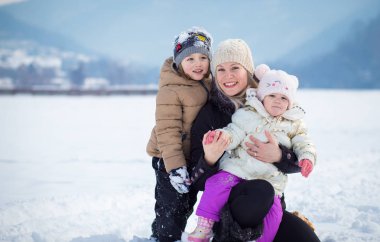 Mutlu aile, kışın oğlu ve kızı olan anne, kış zamanı.