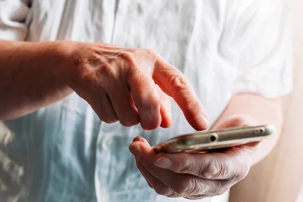 Yaşlı kadın elleri. Dokunmatik ekranlı telefon kullanarak. Yaşlılar ve teknoloji