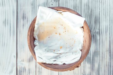 Susamlı ve parçalı boş ahşap kase, ay çöreğinden arta kalanlar..