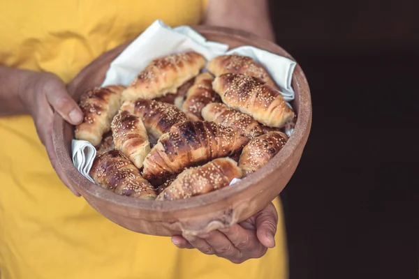 Donna con ciotola piena di croissant appena sfornati. Fare rotoli di mezzaluna — Foto Stock
