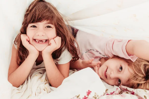かわいい女の子、姉妹の朝に目を覚ます。パジャマを着て寝てる子供たち — ストック写真