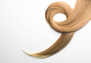 Piece of blonde brown hair on white isolated background