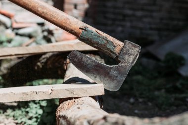 Tahtaya saplanmış eski metal balta. Sıkı el işi