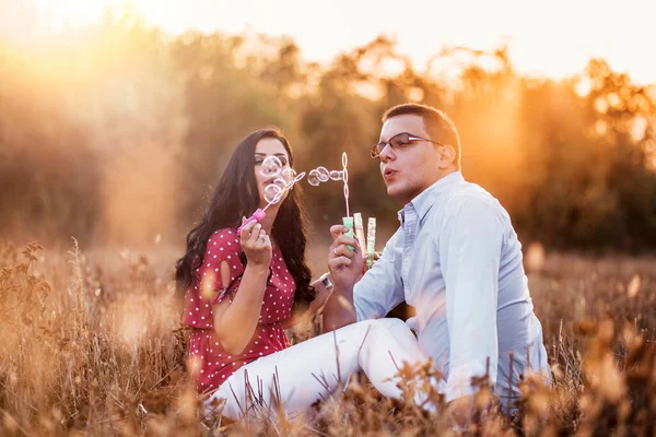 石鹸泡を作る若いカップルの屋外の肖像画 午後の光 ロマンスロマンチックなジェスチャー — ストック写真