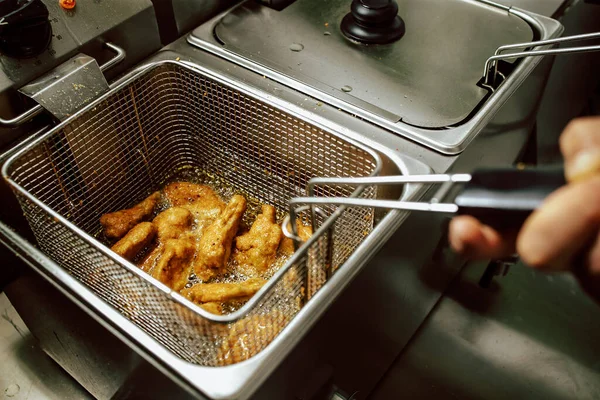 Kızarmış tavuk nuggetları kızartma makinesinde. Restoran yemeği hazırlığı.