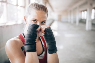 Ellerinde bandajla genç ve formda bir kadın boksör portresi. Spor, aktif yaşam tarzı