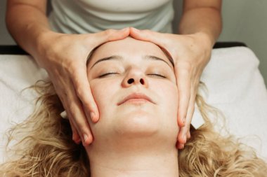 Yüz masajı tedavisine yakın çekim. Genç, beyaz bir kadın. Güzellik tedavileri