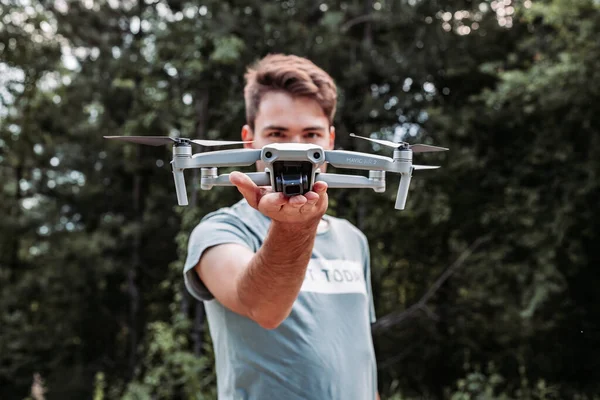 Belgrade, Serbia, June 2020 - Young guy holding drone in his hand in front of his face. Outdoors photo