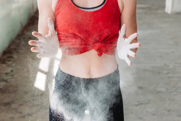Close-up of fit, sporty woman hands clapping with powder, preparing for training. Active lifestyle