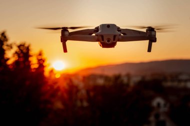 Gün batımında havada uçan bir dronun fotoğrafı.
