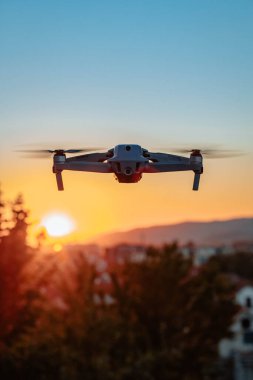 Gün batımında havada uçan bir dronun fotoğrafı.