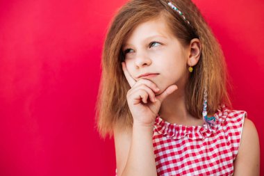 Küçük sarışın kız bir şey düşünüyor. Uzayı kopyala, pembe üzerine izole edilmiş