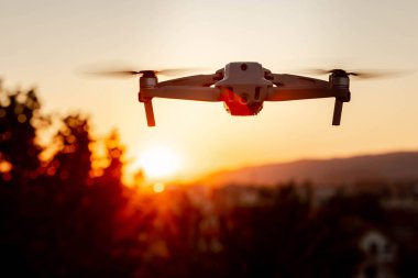 Gün batımında havada uçan bir dronun fotoğrafı.