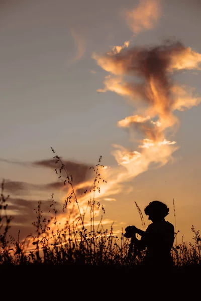 一位女摄影师在麦田里拍摄落日的轮廓 — 图库照片