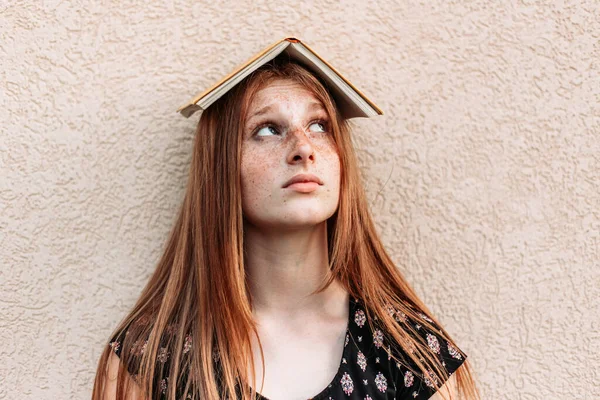 Adolescente Estudante Gengibre Com Livro Cima Cabeça Olhando Para Ele — Fotografia de Stock