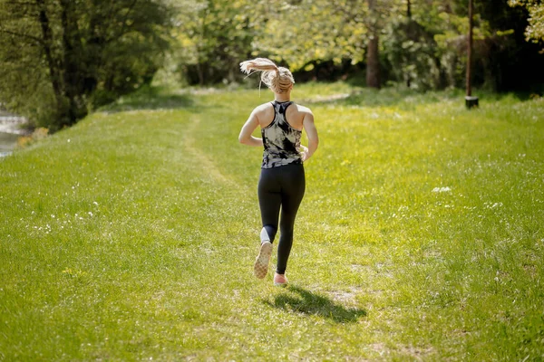 Young blonde girl running in the nature. Healthy lifestyle and sport concept — Stock Photo, Image