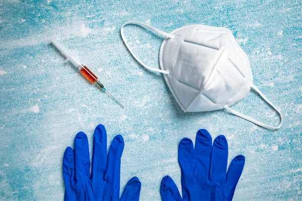 Шприц Красной Жидкостью Медицинская Маска Перчатки Изолированы Синем Фоне Корона — стоковое фото