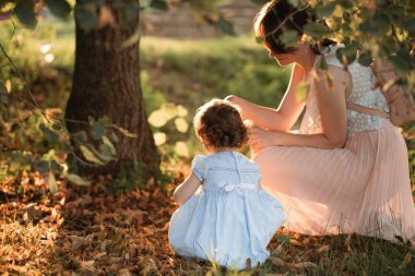 Anne parkta kızıyla oynuyor. Sonbahar zamanı