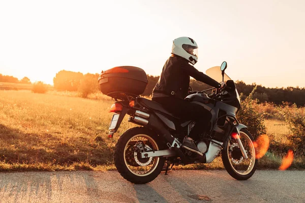 Dişi motorcu bisiklete biner, dinlenir. Öğleden sonra ışığı, boşluğu kopyala