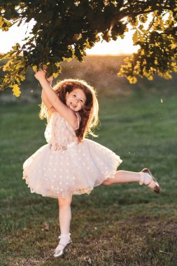 Mutlu kızıl kız parkta oynar, zıplar ve dans eder