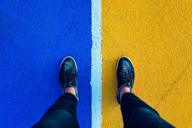 Beyaz çizginin kenarlarında duran kadın bacaklarının üst görüntüsü. Ayrılma kavramı