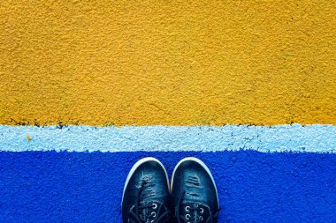 Mavi arka planda beyaz çizginin yanında duran kadın bacaklarının üst görüntüsü. Ayrılma kavramı