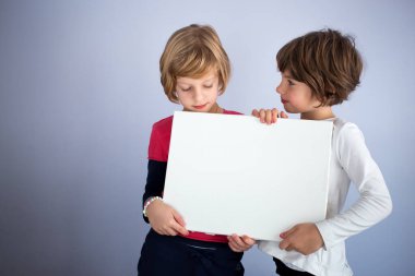 İki küçük kızın elinde boş beyaz tahta var. Boşluğu kopyala, yazmak için boşluk