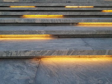 Sarı aydınlatmalı gri mermer merdiven