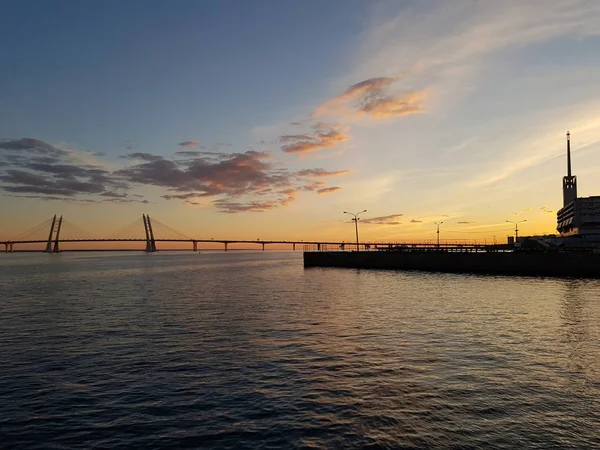 Gün batımının güzel manzarası. Finlandiya Körfezi üzerinde kablolu köprü kaldı. Bulutlar ile harika turuncu-mavi gökyüzü
