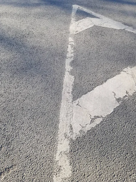 White is a worn-out road marking on a gray asphalt road. Can be used as an abstract background